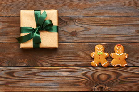Christmas present and homemade gingerbread cookies on wooden background