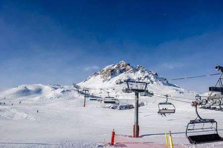 Ski lift in mountains at winter. Alpine winter mountain landscape. French Alps covered with snow in...