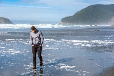 Lone man at beach, autumn. USA Pacific coast landscape, Oregon