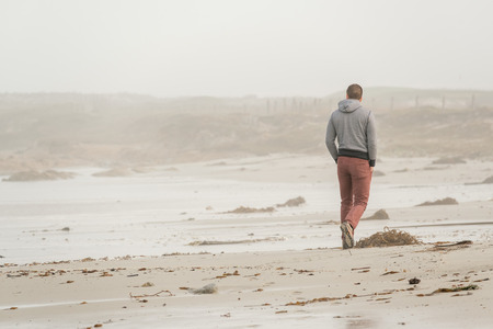 Lone man at beach, autumn. USA Pacific coast landscape, Californiaの写真素材