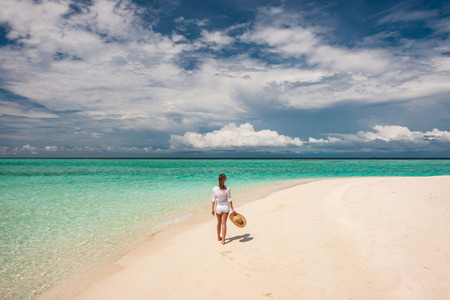 Woman with sun hat on tropical beach at Maldivesの写真素材