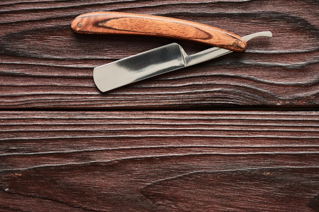 Vintage barber shop straight razor tool on old wooden backgroundの写真素材