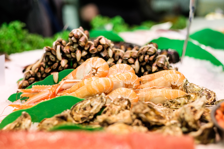 Fresh langoustines, razor clams and oysters at seafood marketの写真素材