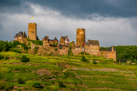 Thurant Castle and vineyards above Moselle river and under dramatic sky near Alken, Germany. Built between 1198 and 1206.のeditorial素材