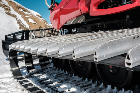 Snow grooming machine (Ratrak). Winter mountain landscape. Caucasus ridge covered with snow in sunny...