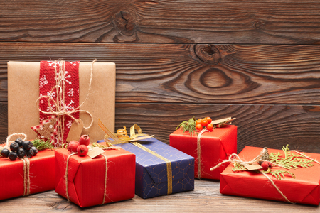 Creatively wrapped and decorated christmas presents in boxes on wooden background. Copy space.の写真素材
