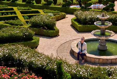 Woman tourist at formal garden in California vineyards, USA.