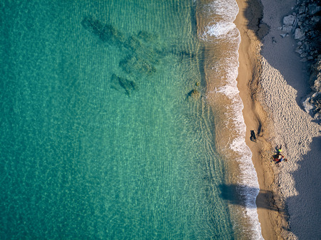 Beautiful beach with family top aerial view drone shot, Sithonia, Greece