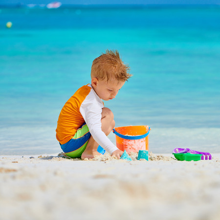 Three year old toddler boy playing with beach toys on beach.  Summer family vacation at Maldives.の写真素材