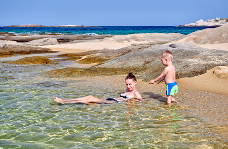 Two year old toddler boy on beach with motherの写真素材