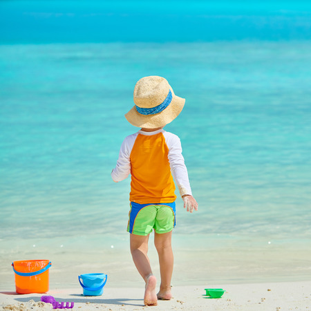 Three year old toddler boy playing with beach toys on beach. Summer family vacation at Maldives.の写真素材