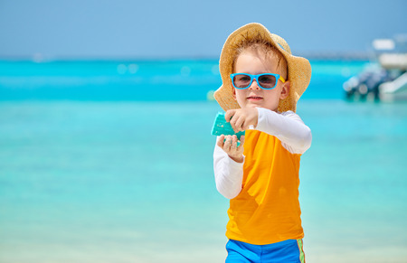 Three year old toddler boy playing with beach toys on beach. Summer family vacation at Maldives.の写真素材