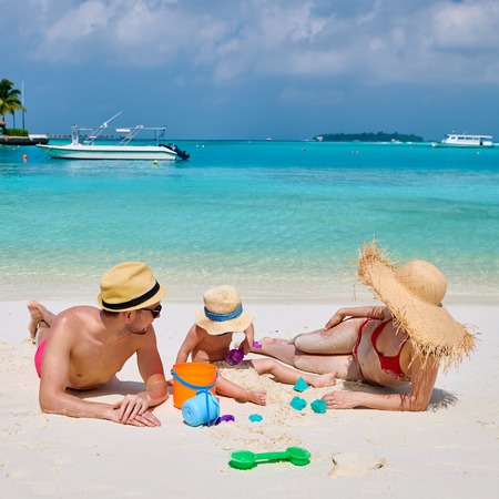 Family on beach, young couple with three year old boy. Summer vacation at Maldives.の写真素材
