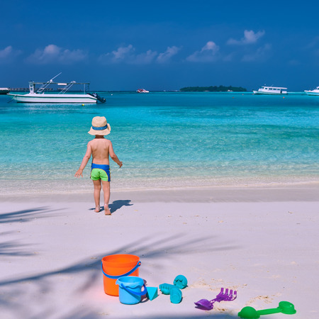 Three year old toddler boy playing with beach toys on beach.  Summer family vacation at Maldives.の写真素材