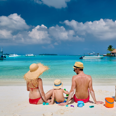 Family on beach, young couple with three year old boy. Summer vacation at Maldives.の写真素材