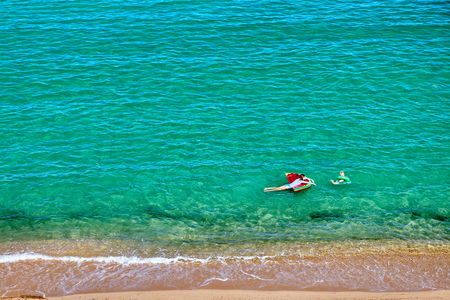 Two year old toddler boy and his mother on beach with inflatable float and ring. Summer family vacation. Sithonia, Greece.の写真素材
