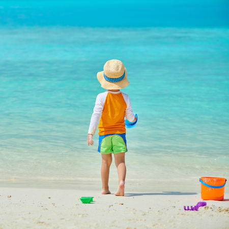 Three year old toddler boy playing with beach toys on beach. Summer family vacation at Maldives.の写真素材