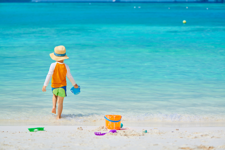 Three year old toddler boy playing with beach toys on beach. Summer family vacation at Maldives.の写真素材