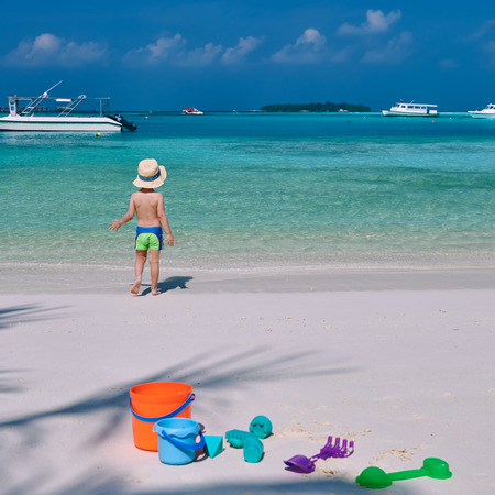 Three year old toddler boy playing with beach toys on beach.  Summer family vacation at Maldives.の写真素材