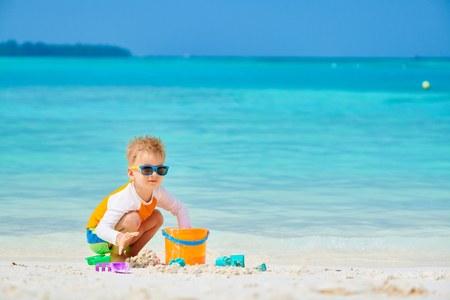 Three year old toddler boy playing with beach toys on beach.  Summer family vacation at Maldives.の写真素材