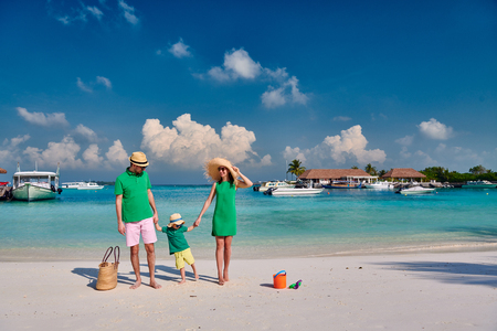 Family on beach, young couple in green with three year old boy. Summer vacation at Maldives.の写真素材