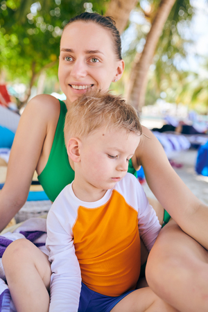 Three year old toddler boy at tropical beach resort with mother. Summer family vacation at Maldives.の写真素材