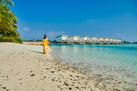 Woman in dress walking on tropical beach. Summer vacation at Maldives.の写真素材