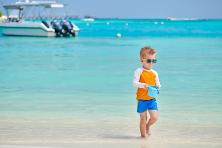 Three year old toddler boy playing with beach toys on beach. Summer family vacation at Maldives.の写真素材