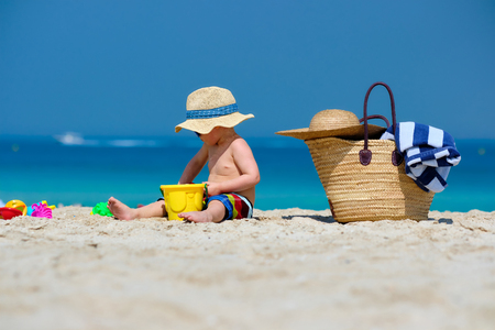 Two year old toddler boy playing with beach toys on beachの写真素材