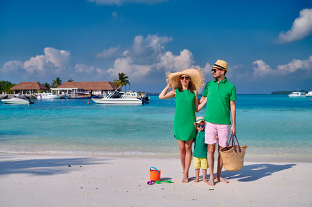 Family on beach, young couple in green with three year old boy. Summer vacation at Maldives.の写真素材