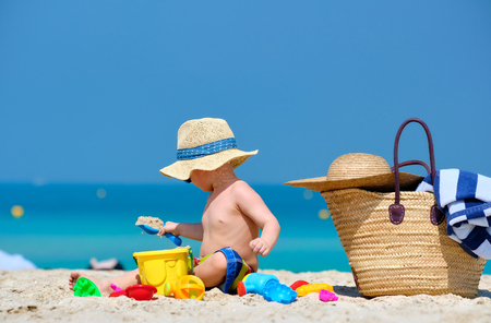 Two year old toddler boy playing with beach toys on beachの写真素材