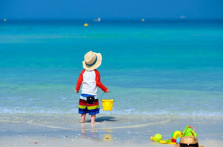 Two year old toddler boy playing with beach toys on beachの写真素材