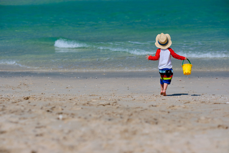 Two year old toddler boy playing with beach toys on beachの写真素材