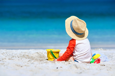 Two year old toddler boy playing with beach toys on beachの写真素材