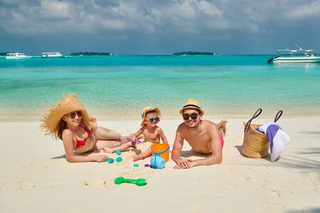 Family on beach, young couple with three year old boy. Summer vacation at Maldives.の写真素材