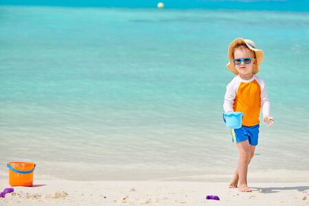 Three year old toddler boy playing with beach toys on beach. Summer family vacation at Maldives.の写真素材