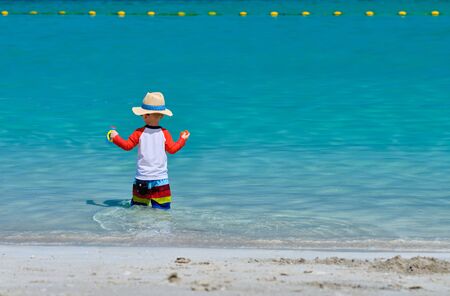 Two year old toddler boy playing with beach toys on beachの写真素材