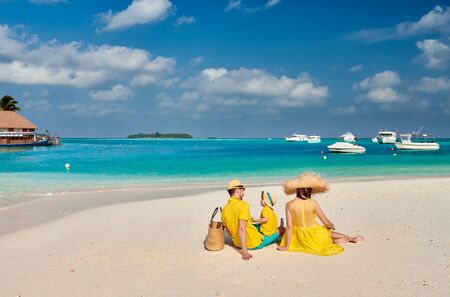 Family on beach, young couple in yellow with three year old boy. Summer vacation at Maldives.の写真素材