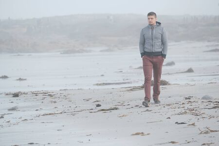 Lone man at beach, foggy autumn day. USA Pacific coast landscape, Californiaの写真素材