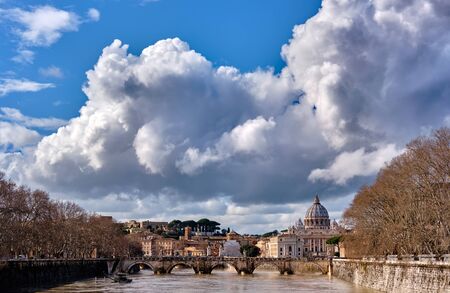 St. Peter's cathedral and Tiber river with high water in February. Saint Peter Basilica in Vatican city with Saint Angelo Bridge in Rome, Italyの写真素材