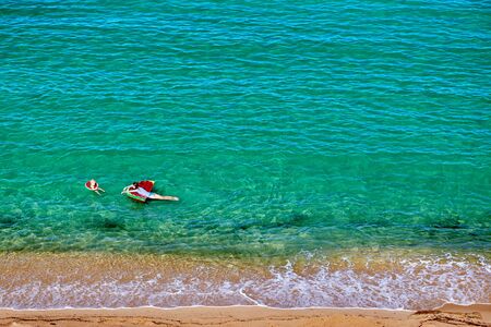 Two year old toddler boy and his mother on beach with inflatable float and ring. Summer family vacation. Sithonia, Greece.の写真素材