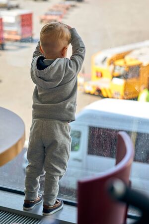 Two year old boy at the airport looking at planeの写真素材