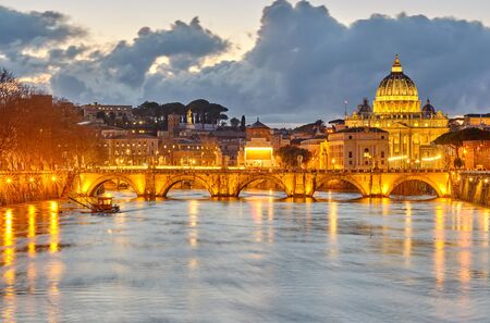 St. Peter's cathedral and Tiber river with high water at evening. Saint Peter Basilica in Vatican city with Saint Angelo Bridge in Rome, Italyの写真素材
