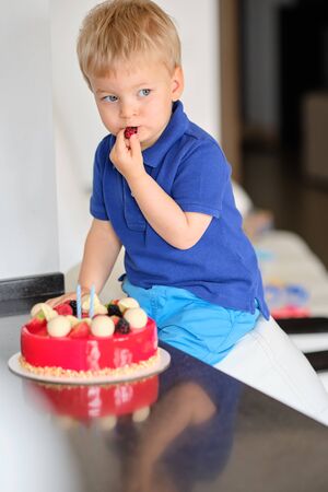 Two year old boy trying birthday cakeの写真素材