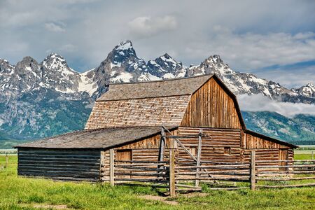 Old mormon barn in Grand Teton Mountains with low clouds. Grand Teton National Park, Wyoming, USA.の写真素材