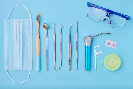 Dentist tools over light blue background top view flat lay. Tooth care, dental hygiene and health concept.の写真素材