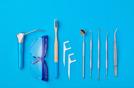 Dentist tools over blue background top view flat lay. Tooth care, dental hygiene and health concept.の写真素材