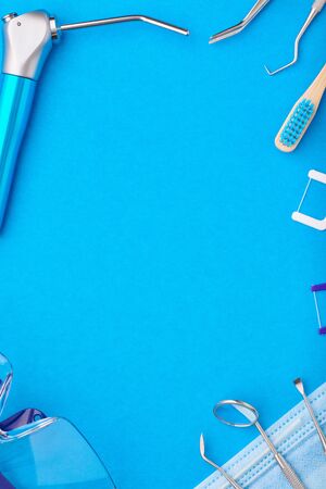 Dentist tools over blue background top view copy space flat lay. Tooth care, dental hygiene and health concept.の写真素材