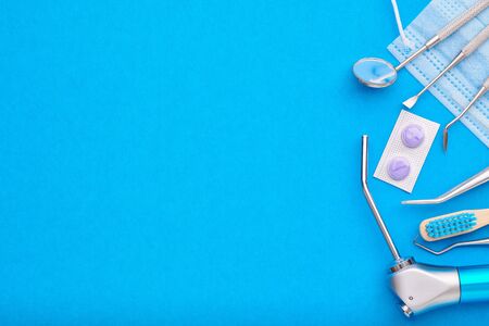 Dentist tools over blue background top view copy space flat lay. Tooth care, dental hygiene and health concept.の写真素材