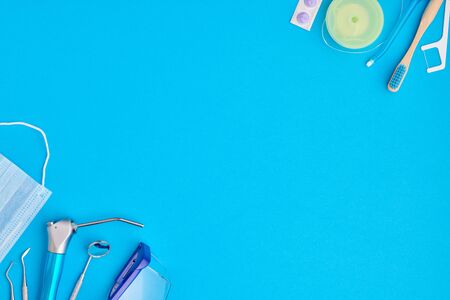 Dentist tools over blue background top view copy space flat lay. Tooth care, dental hygiene and health concept.の写真素材